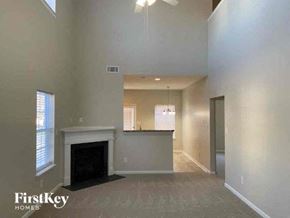 Matthews house for rent - a large empty living room with a fireplace