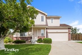 Aurora house for rent - a suburban house with a garage door and a tree