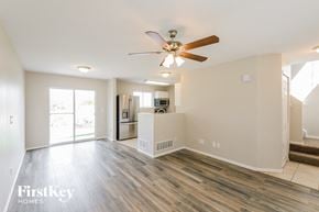 Aurora house for rent - an empty living room with a ceiling fan and a kitchen