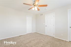 Aurora house for rent - a bedroom with white walls and a ceiling fan