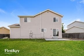Aurora house for rent - the outside of a house with a grass yard and a fence