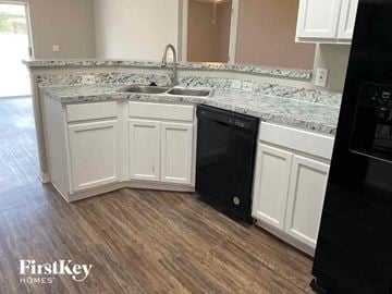 Saint Cloud house for rent - a kitchen with white cabinets and a black dishwasher