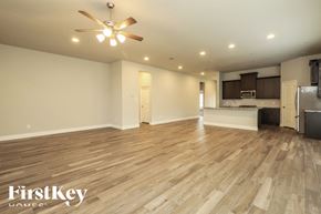 Seguin house for rent - A spacious room with wooden flooring and a ceiling fan.