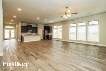 Seguin house for rent - A spacious living room with wooden flooring and a ceiling fan.