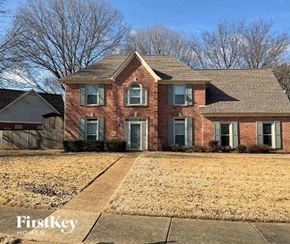 Collierville house for rent - A brick house with a First Key Homes sign in front.