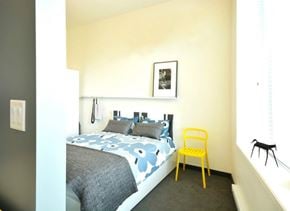 Winnipeg apartment for rent - a bedroom with a bed and a yellow chair