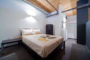 Winnipeg apartment for rent - a bedroom with a bed in a room with a wooden ceiling