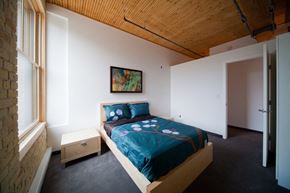 Winnipeg apartment for rent - a bedroom with a bed in a room with a wooden ceiling