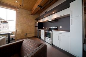 Winnipeg apartment for rent - a kitchen with white cabinets and a stove top oven