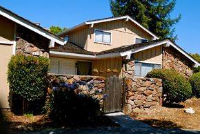 San Jose apartment for rent - a house with a stone wall and a wooden gate