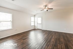 Conroe house for rent - an empty living room with wood floors and a ceiling fan