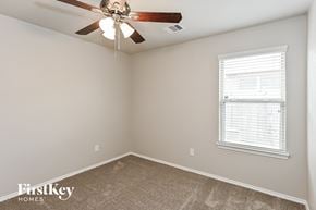 Conroe house for rent - a bedroom with a ceiling fan and a window