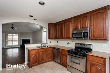 Forney house for rent - A kitchen with wooden cabinets and a stove top oven.