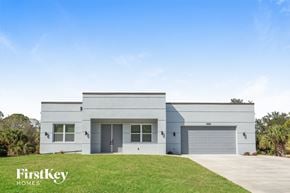 North Port house for rent - a white house with two garage doors and a lawn