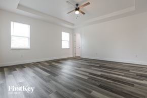 North Port house for rent - the living room of a new home with wood flooring and a ceiling fan