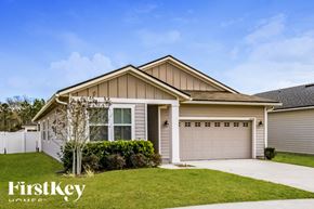 Fernandina Beach house for rent - A house with a garage and a tree in front of it.