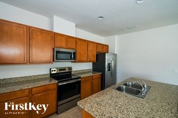 Fernandina Beach house for rent - A kitchen with brown cabinets and a granite countertop.