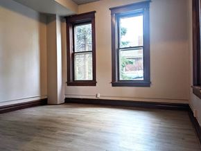 Hobart apartment for rent - an empty room with two windows and wood floors