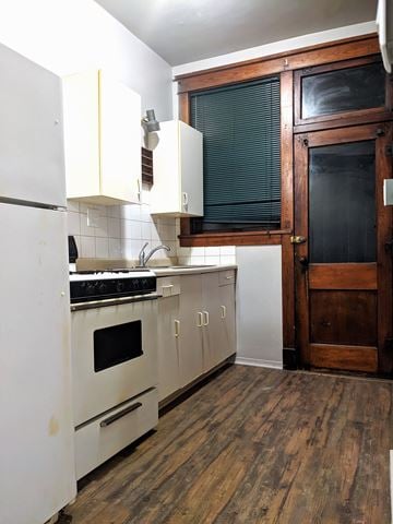 Hobart apartment for rent - a small kitchen with white cabinets and a stove and a refrigerator