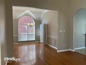 Arlington house for rent - an empty living room with a large window and wooden floors