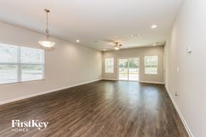Jacksonville house for rent - A spacious room with wooden flooring and a ceiling fan.