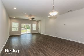 Jacksonville house for rent - A spacious room with wooden flooring and a ceiling fan.