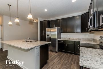 Jacksonville house for rent - A kitchen with a granite countertop and black cabinets.