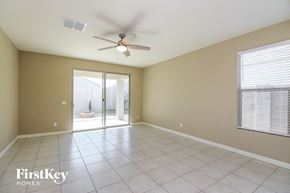 San Tan Valley house for rent - an empty living room with a ceiling fan and a sliding glass door