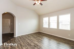 Baytown house for rent - an empty living room with a ceiling fan and windows