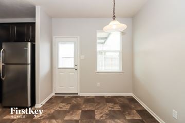 Baytown house for rent - a kitchen with a refrigerator and a door and a window