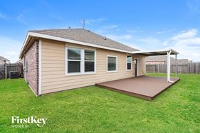 Baytown house for rent - a small tan house with a deck and a grassy yard