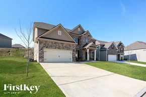 Dallas house for rent - A large house with a stone facade and a garage is for sale.