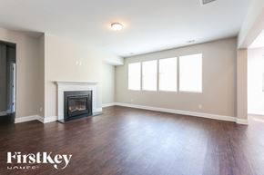 Dallas house for rent - A spacious living room with a fireplace and wood flooring.