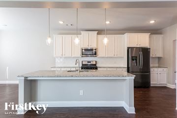 Dallas house for rent - A kitchen with a granite countertop and a refrigerator.
