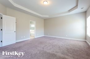 Dallas house for rent - A spacious room with a carpeted floor and a door on the left side.
