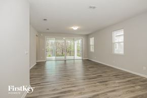Jacksonville house for rent - the living room and dining room of an empty house with wood flooring