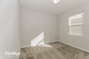 Jacksonville house for rent - a bedroom with white walls and carpet and a window