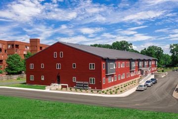 Albany apartment for rent - a rendering of a red building with cars parked in front of it