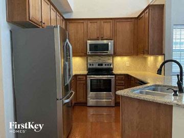Charlotte house for rent - a kitchen with wooden cabinets and stainless steel appliances