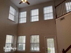 Charlotte house for rent - a living room with six windows and a ceiling fan