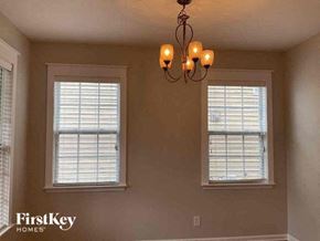 Charlotte house for rent - a living room with two windows and a chandelier