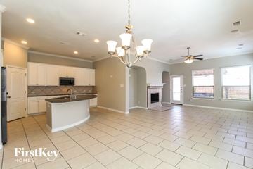 Little Elm house for rent - an open kitchen and living room with white cabinets and tiled flooring