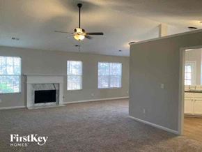 Dacula house for rent - an empty living room with a ceiling fan and a fireplace