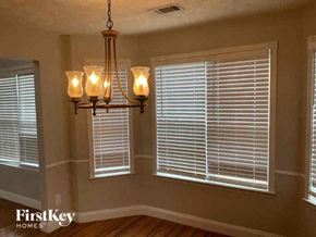 Kennesaw house for rent - a dining room with a chandelier and windows with blinds