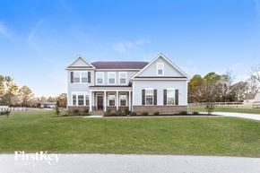 Willow Spring house for rent - A white house with a brown roof and a sign that says "FirstKey Homes".