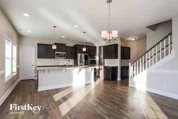 Willow Spring house for rent - A spacious kitchen and living room with wooden floors and a staircase.
