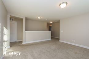 Willow Spring house for rent - A spacious empty room with a carpeted floor and white walls.