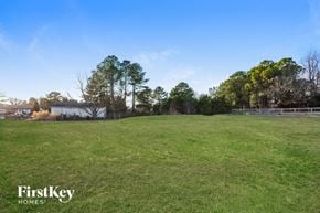 Willow Spring house for rent - A grassy field with trees and a fence in the distance.