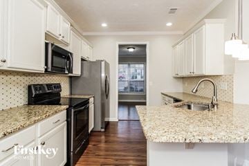 Canton house for rent - A kitchen with white cabinets and granite countertops.