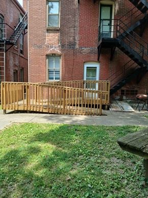 Louisville apartment for rent - a wooden deck in front of a brick building